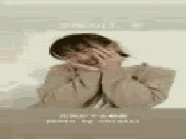 a woman is covering her face with her hands while smiling .