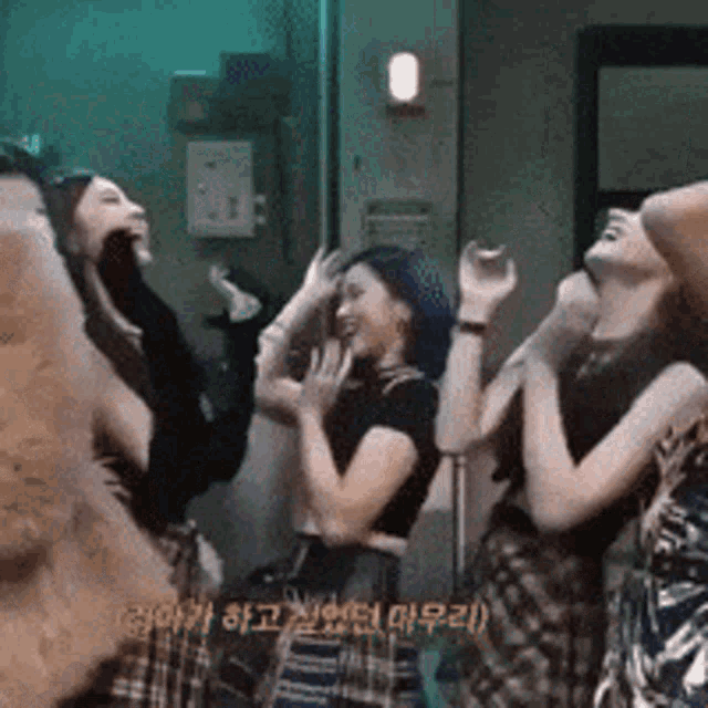 a group of young women are standing next to each other laughing and dancing .