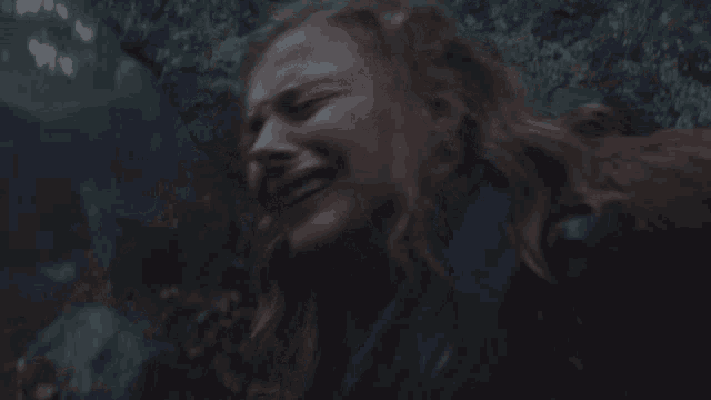 a woman is crying in a dark room with a blurry background