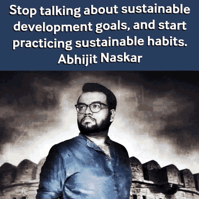 a man with glasses stands in front of a brick wall with a quote from abhijit naskar