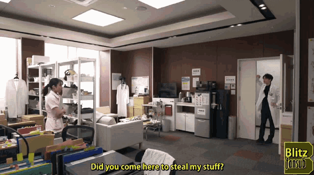 a man in a white lab coat is standing in a room with a sign that says blitz fansub