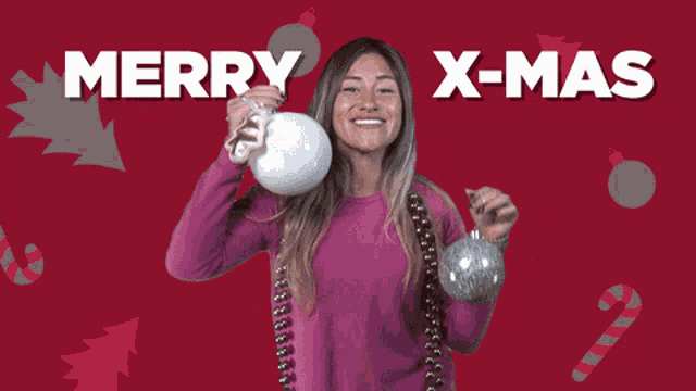 a woman in a pink sweater is holding two christmas ornaments and the words merry x-mas are above her