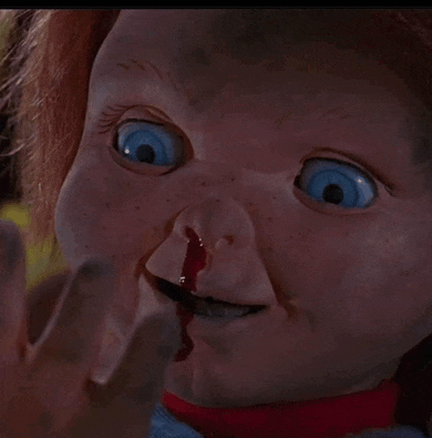 a close up of a doll 's face with blood coming out of its nose .