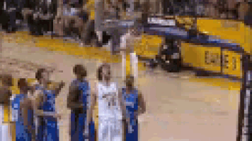 a group of basketball players are standing on a court and talking to each other .