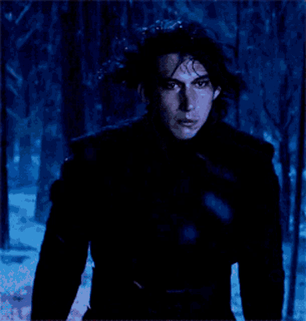 a man in a black coat is standing in the snow