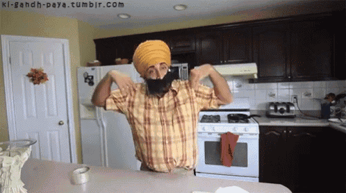 a man wearing a turban and a fake beard is in a kitchen