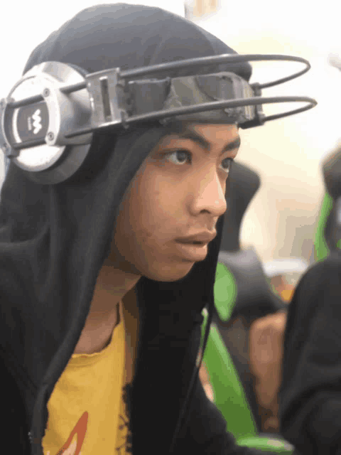 a boy wearing headphones and goggles has the letter m on the headphones