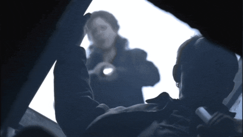a man is holding a flashlight in front of a woman