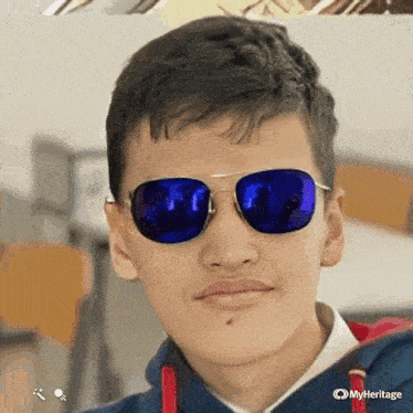 a young man wearing blue sunglasses and a red hoodie