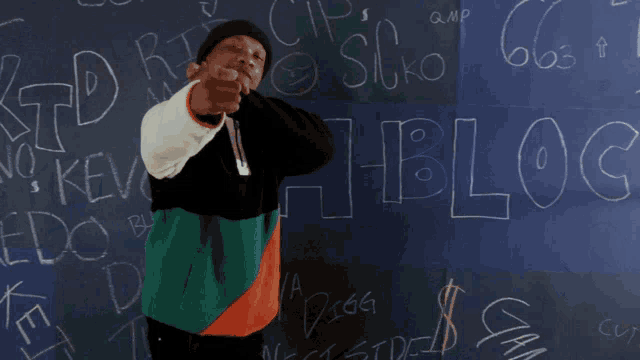 a man is dancing in front of a blackboard that says " blocc "