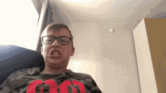 a young man wearing glasses and a shirt that says fg