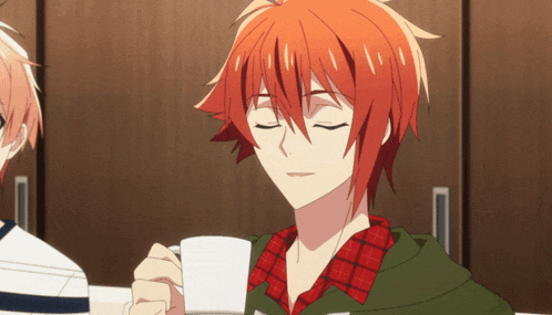 a man with red hair is holding a white cup