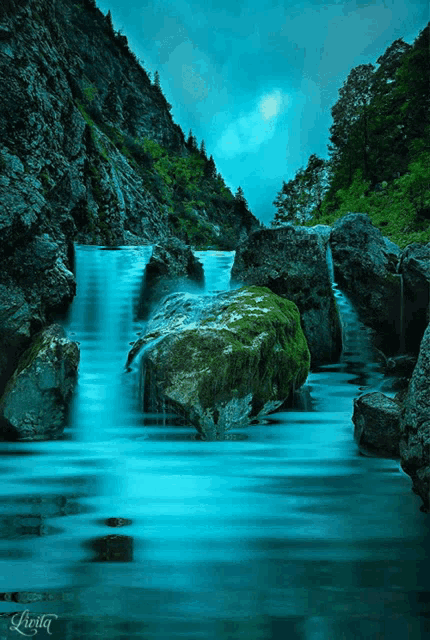 a picture of a waterfall with the name leota on the bottom left