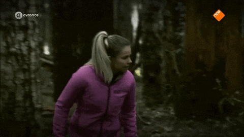 a woman in a pink jacket is running in the woods on a channel called avrotros