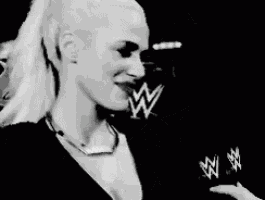 a black and white photo of a woman wearing a necklace with the letter w on it