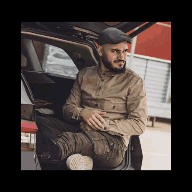 a man is sitting in the back of a car with the trunk open