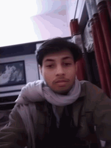 a man wearing a scarf around his neck is laying down