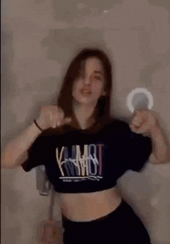 a blurry picture of a woman wearing a black crop top dancing .