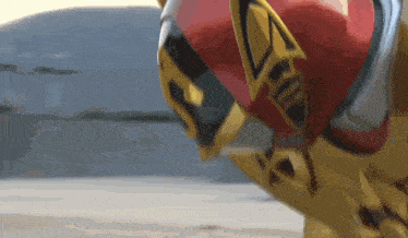 a close up of a cartoon character wearing a red and gold suit