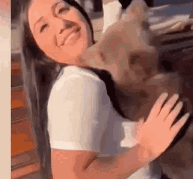 a woman is holding a dog in her arms while smiling .
