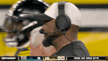 a man wearing headphones is watching a football game on espn .