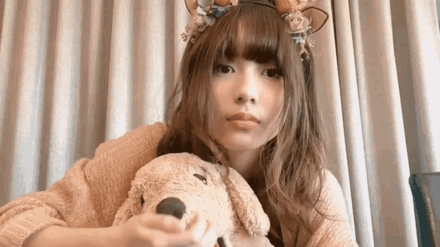 a woman wearing a headband and holding a stuffed dog