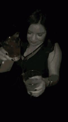 two people are holding glasses of alcohol in their hands .