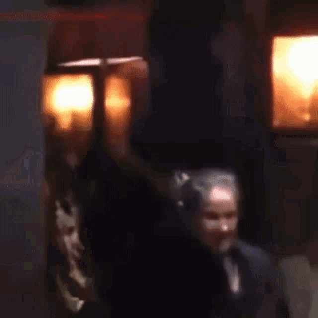 a blurry picture of a group of people dancing in a dark room .