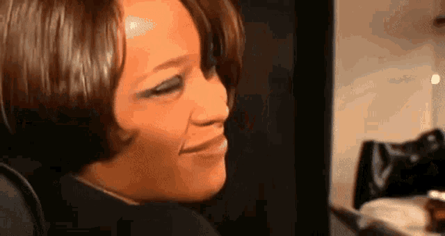 a close up of a woman 's face with her eyes closed and a smile on her face .