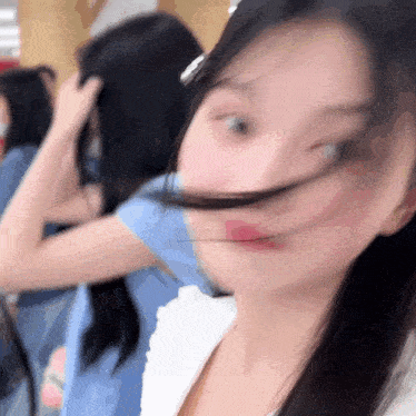 a blurry picture of a woman 's face with her hair blowing in the wind