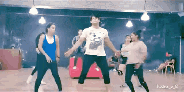 a group of people are dancing in a room with the name h33na written on the bottom