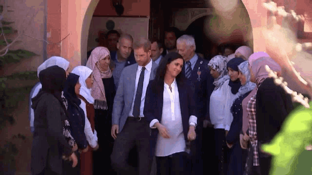 a group of people are standing in front of a building with a sign that says ' welcome ' on it