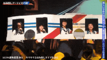 a group of people are standing in front of a cardboard box that says agi on it