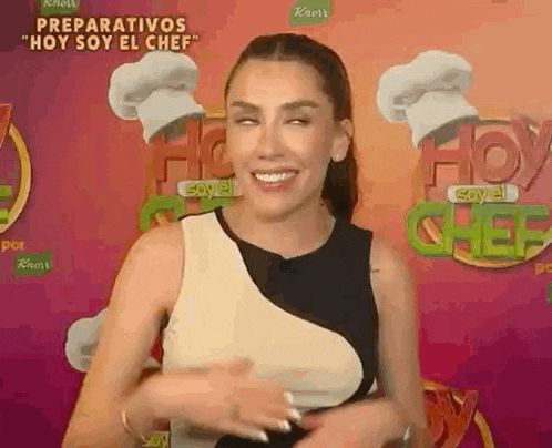 a woman is making a funny face in front of a chef hat .