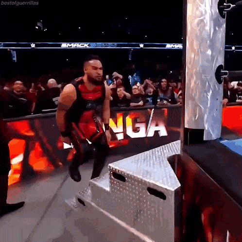 a wrestler is walking down stairs in front of a sign that says smack on it