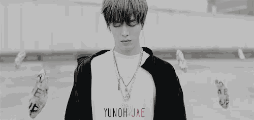 a black and white photo of a young man with a necklace and a glitch effect .