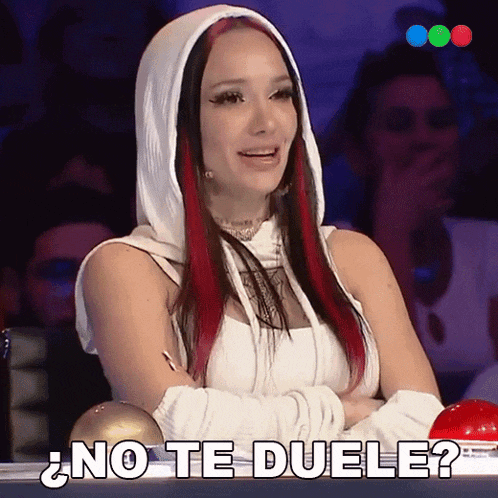a woman with red hair is sitting in front of a red button that says no te duele