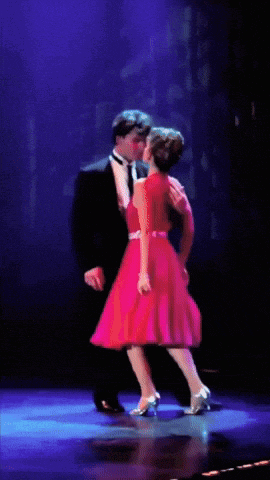 a woman in a pink and white dress is dancing on a stage