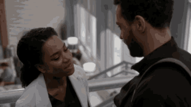 a man and a woman are looking at each other in a room
