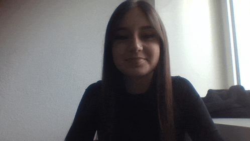 a woman in a black shirt looks at the camera