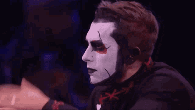 a man with white paint on his face and a black shirt