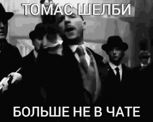 a black and white photo of a man in a suit and tie with a caption in russian that says tomac shelbi