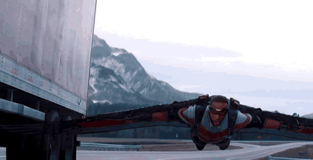 a man in a superhero costume is flying through the air