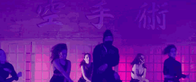a group of dancers are performing in front of a sign that says karate