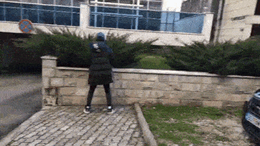a person standing on a sidewalk in front of a building .