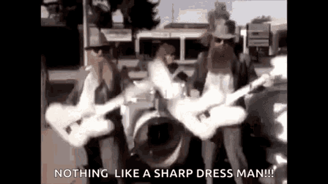 a man with a beard is playing a guitar in a band while another man plays drums .