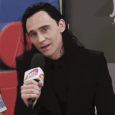 a man in a black suit is holding a microphone that says wicked on it