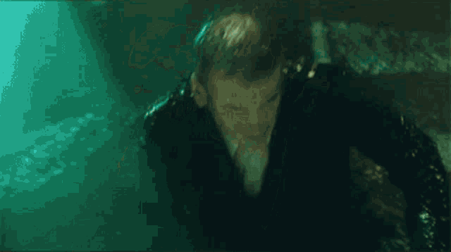 a man in a black suit is standing in a pool of water