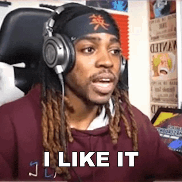 a man with dreadlocks is wearing headphones and says i like it