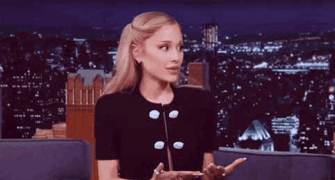 ariana grande is wearing a black jacket with white buttons on it
